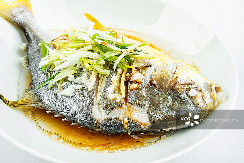 中餐家常菜清蒸金昌鱼在白背景上图片素材