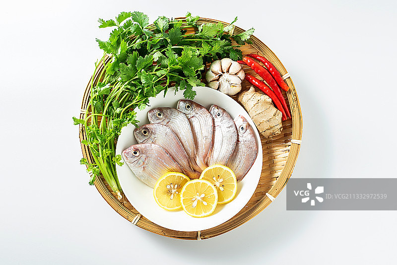 一竹盘装着新鲜红鲷鱼和香料食材图片素材