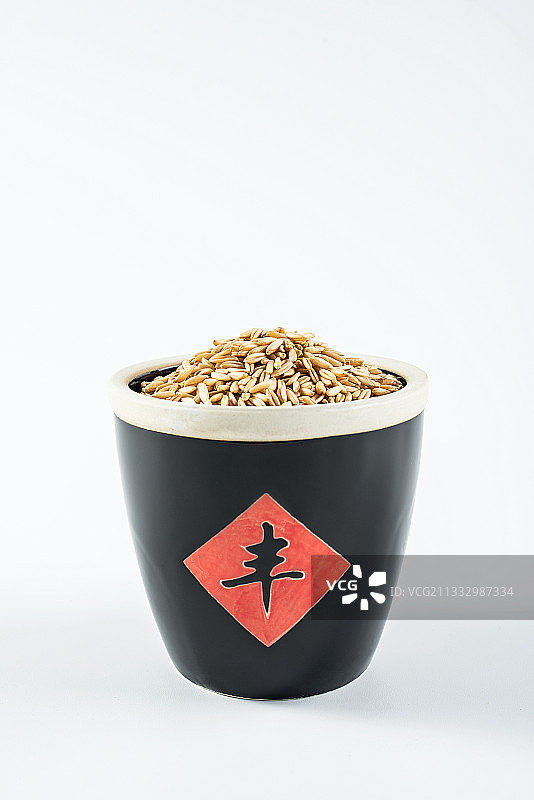 白背景上一只米缸装满白燕麦仁图片素材