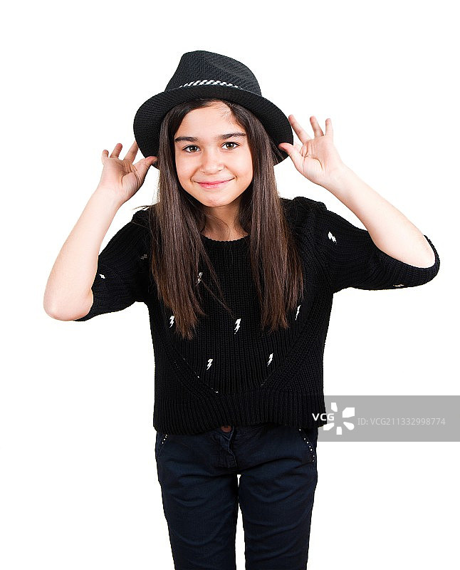 戴着帽子站在白色背景前的微笑女孩肖像图片素材