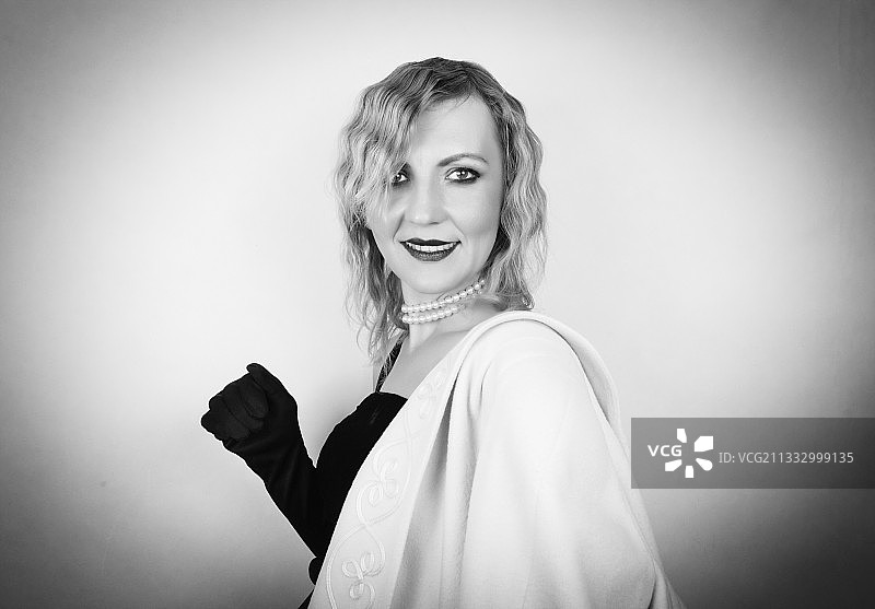 站在灰色背景前的微笑女人图片素材