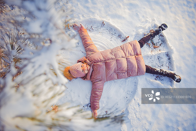 小女孩在阳光明媚美丽的冬日玩耍图片素材