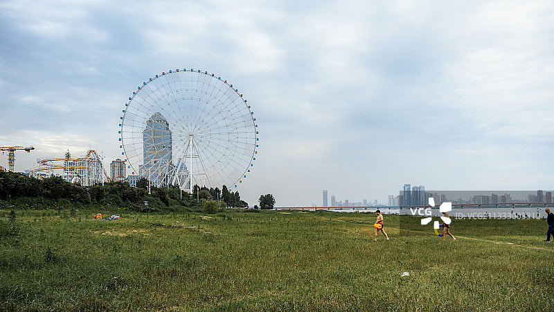 摩天轮下赣江边上游泳的人图片素材