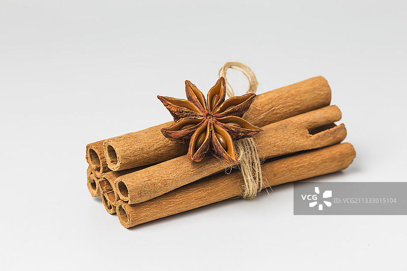 白色背景容器中的肉桂棒和八角特写图片素材