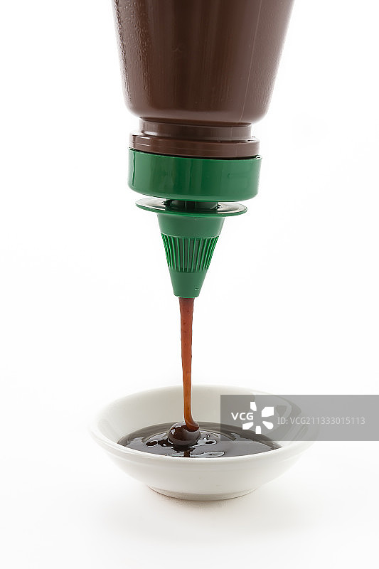 移液管将烧烤酱倒入瓶中（白色背景特写）图片素材