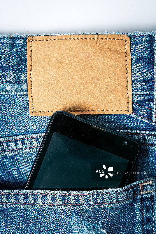 牛仔裤口袋里的智能手机特写图片素材