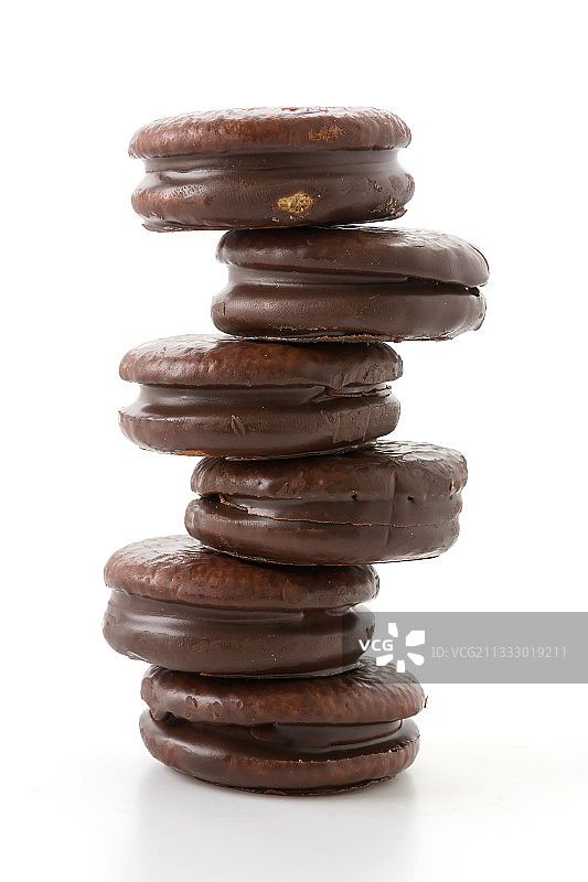 白色背景下堆叠的巧克力曲奇特写图片素材