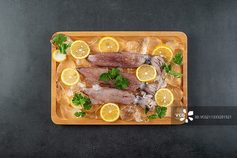 黑色背景上一盘新鲜小管鱿鱼图片素材