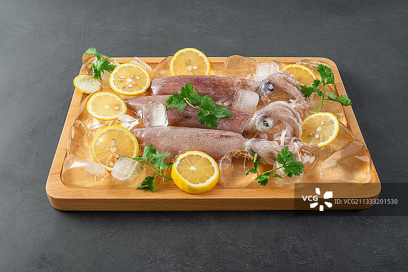 黑色背景上一盘新鲜小管鱿鱼图片素材