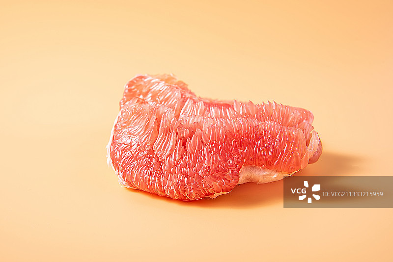 黄色背景上的新鲜红色柚子肉图片素材