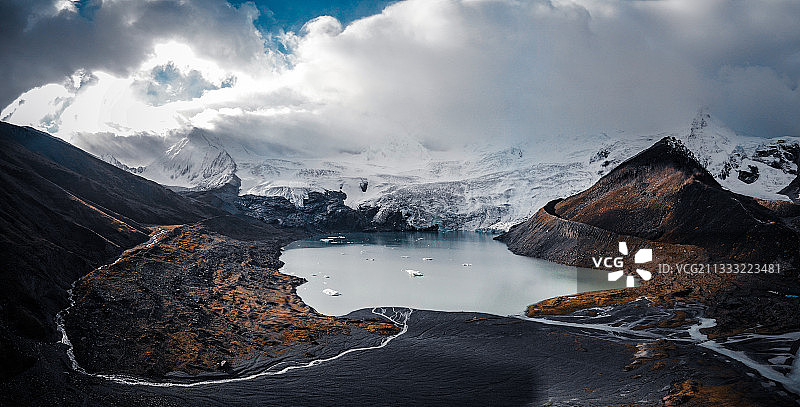 中国西藏雪山神山圣湖的航拍辫状水系注入湖泊风光图片素材