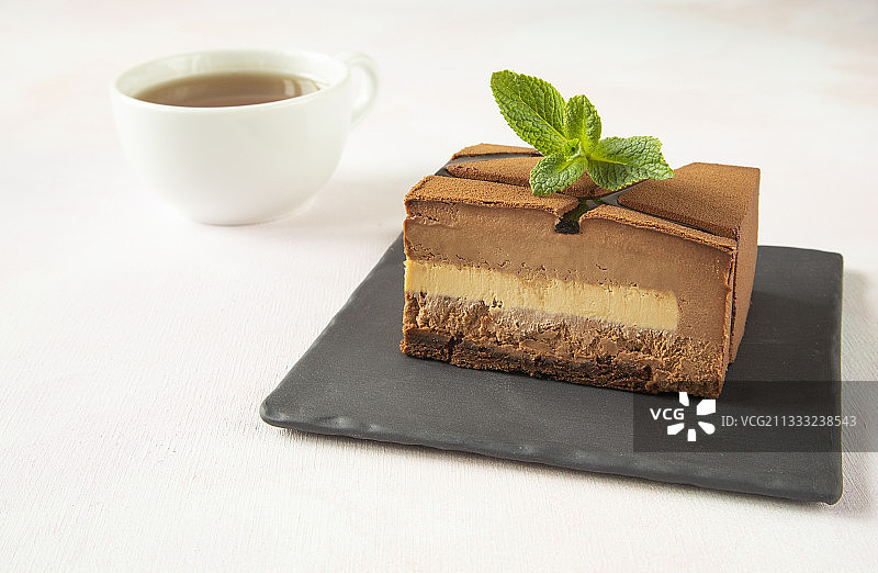 黑色方盘上的一块现代巧克力蛋糕图片素材