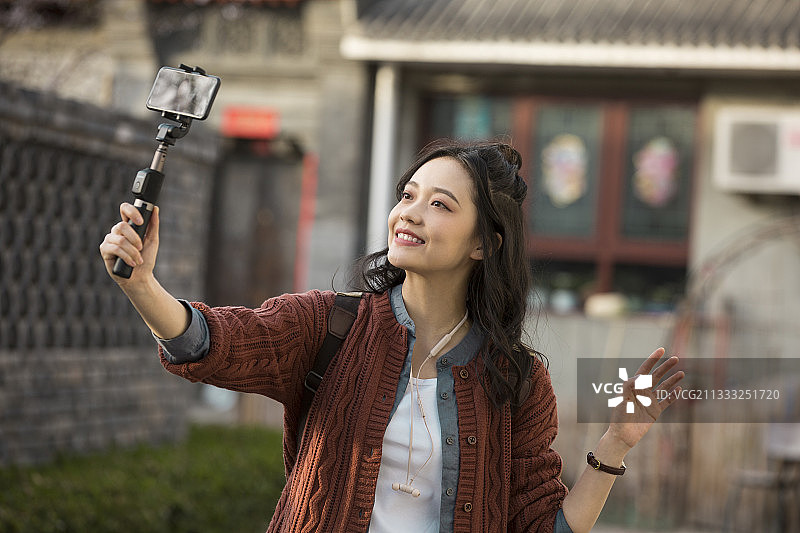 青年女子视频直播城市胡同旅行图片素材