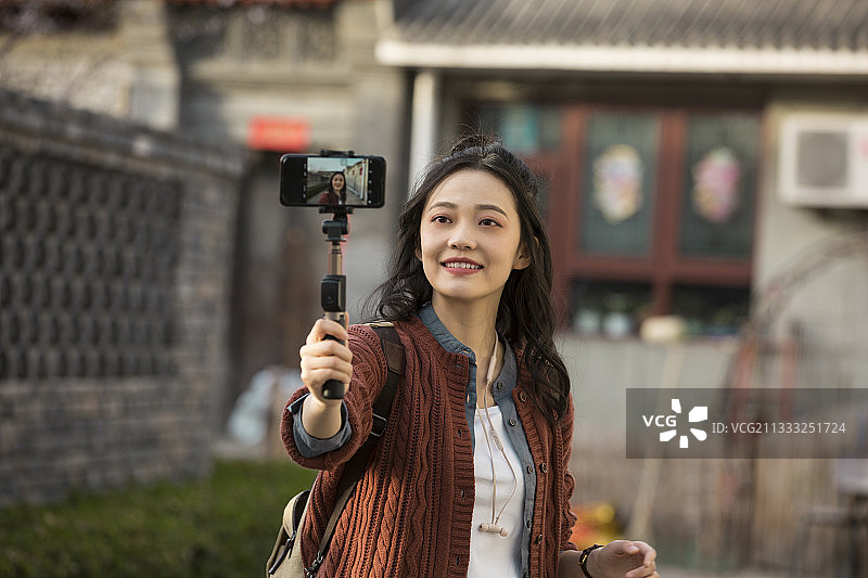青年女子视频直播城市胡同旅行图片素材
