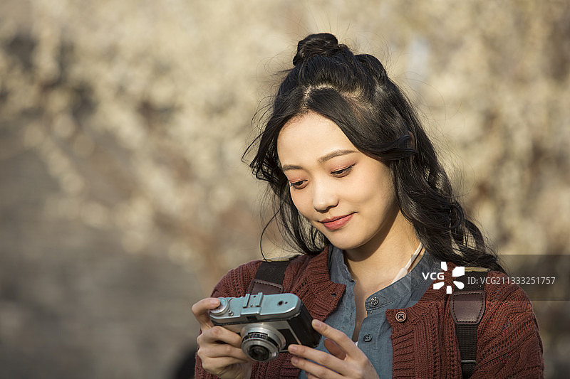 青年女子城市旅行拍照看樱花和桃花图片素材