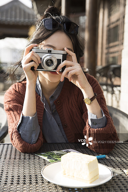 青年女子城市旅行拍照在户外咖啡馆图片素材
