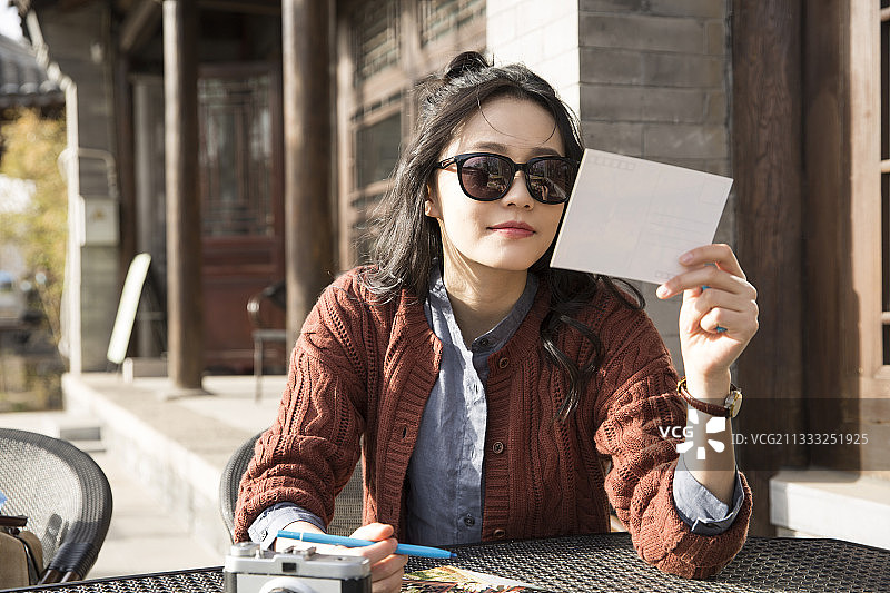 青年女子城市旅行在户外咖啡馆休息写明信片图片素材