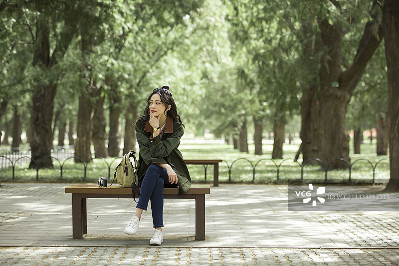 青年女子在城市公园听音乐放松休息图片素材