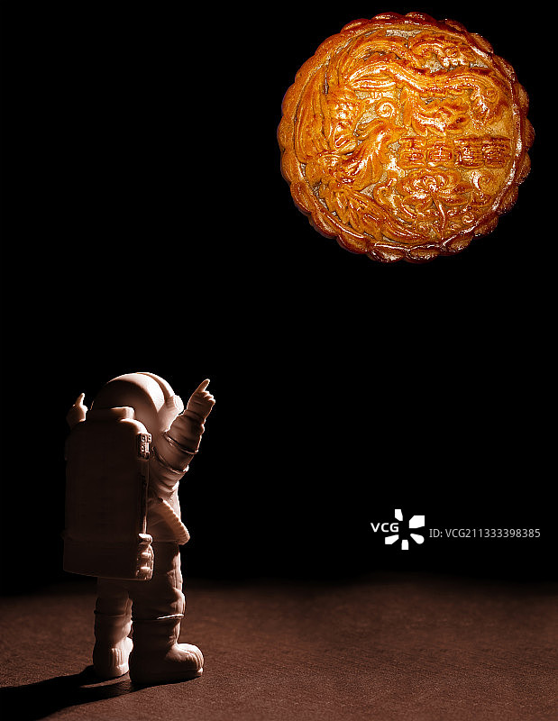 宇航员看着远方模拟月亮的中秋月饼图片素材