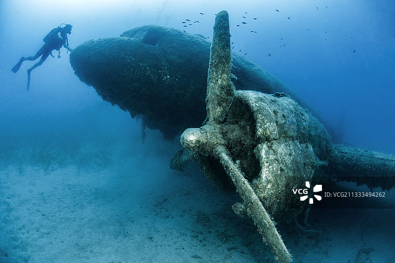 在土耳其卡斯-凯科瓦海洋保护区沉没的达科他DC3飞机残骸前的潜水员图片素材