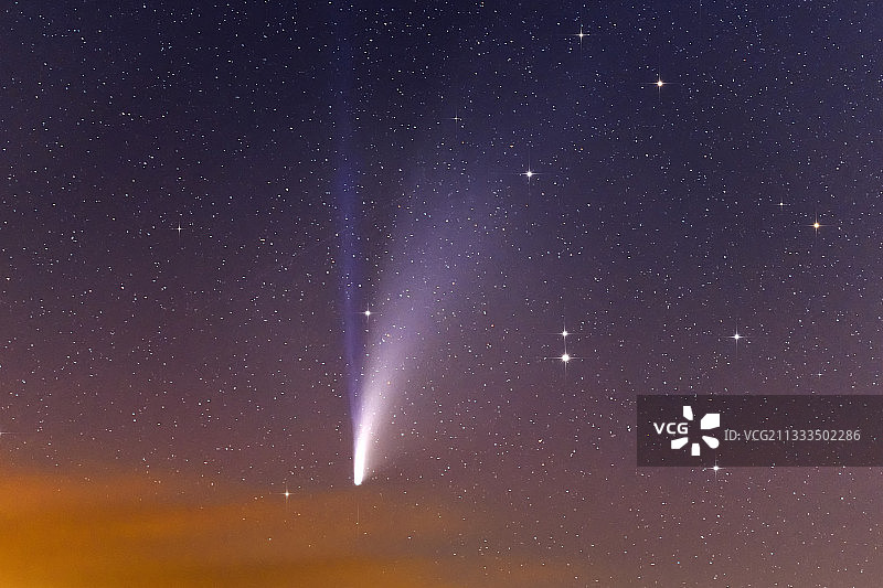 夜空中的 NEOWISE 彗星，其双尾由离子（蓝色）以及尘埃和水（白色羽状物）组成，法国图片素材