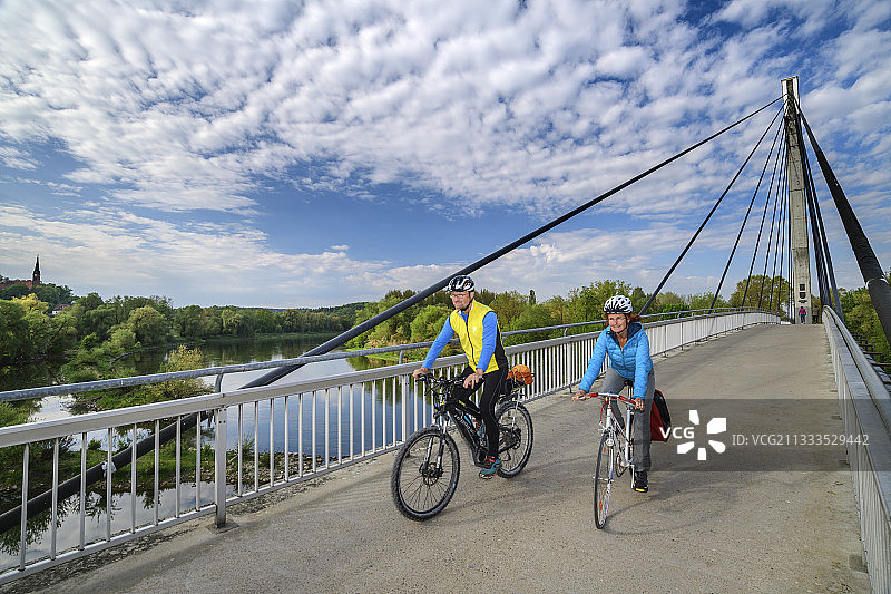 男人和女人骑自行车越过Charbonniere-les-Bains桥,多瑙河自行车道,Bad Abbach,Lowe图片素材