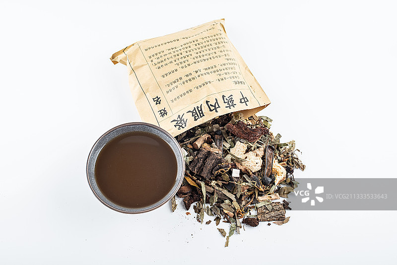 白背景上一堆中药材和一碗熬煮好的药汤图片素材