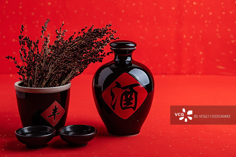 红色背景上一壶中国高粱酒和高粱穗图片素材