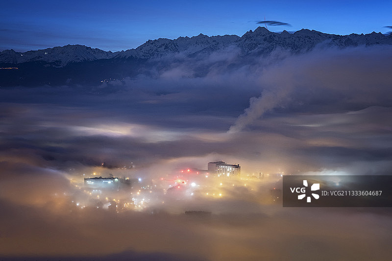 黄昏时格勒诺布尔和特隆切的浓雾，面对贝勒多纳山脉。格勒诺布尔及其郊区在清晨的雾气。贝勒多纳山脉被新兴的日光照亮。图片素材