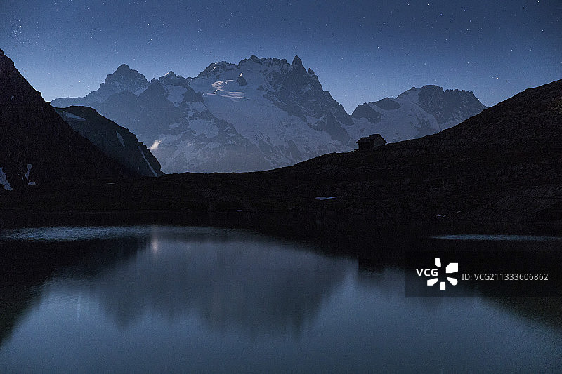 法国上阿尔卑斯省埃克兰国家公园瓦桑山区夜晚的戈莱翁湖(2438米)，背景是被月光照亮的梅耶峰(3983米)和拉克峰(3809米)图片素材