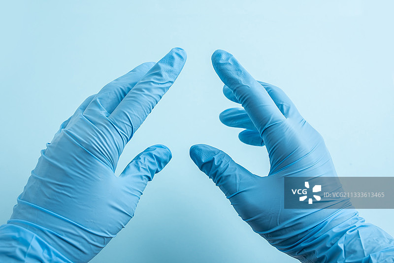 双手戴着蓝色一次性手套的医护人员图片素材