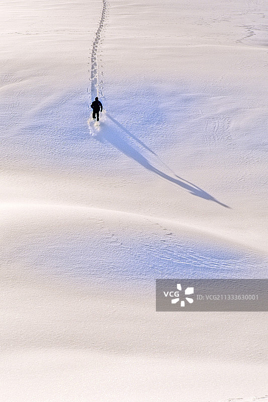 在未受破坏的雪地上穿着雪鞋的徒步旅行者图片素材