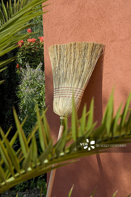 普罗旺斯红墙上的天然纤维扫帚图片素材