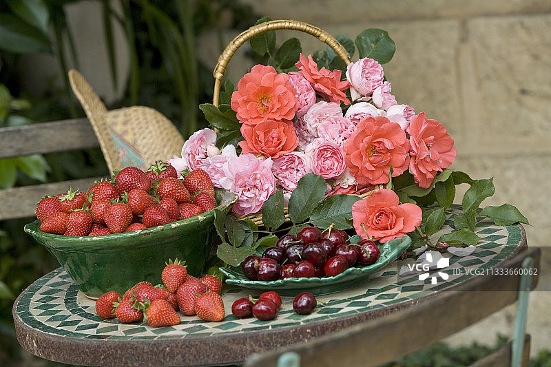 花园桌上的玫瑰与红色水果静物摄影图片素材