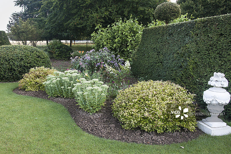 花园里的绣线菊与雕塑图片素材
