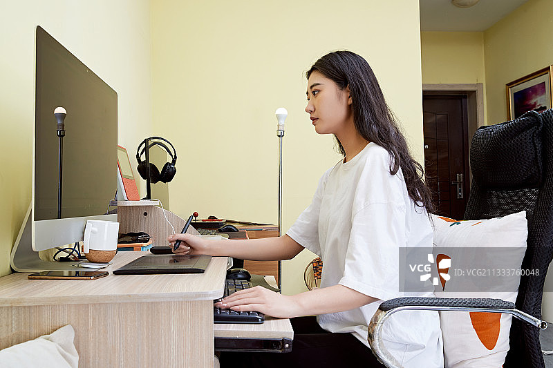 居家在电脑前创作插画的年轻美女图片素材