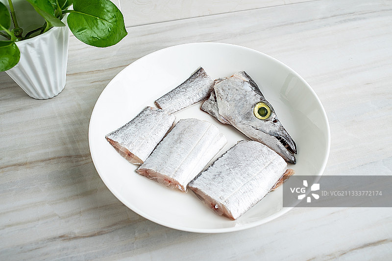厨房瓷砖台面上一碟新鲜切断的带鱼块图片素材