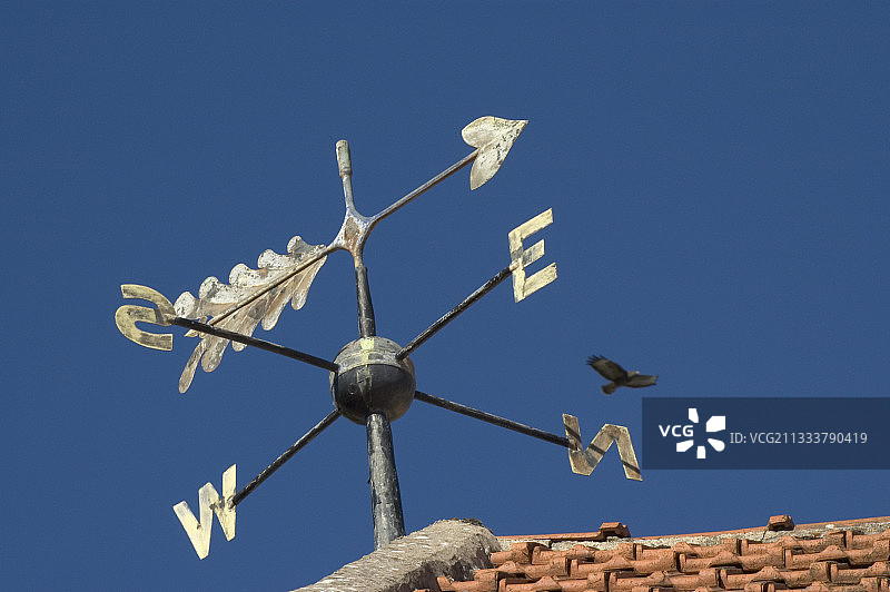 固定在红色瓦屋顶上的风向标图片素材