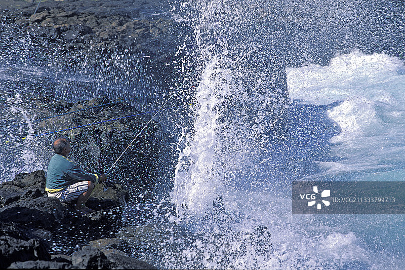 在留尼汪岛圣皮埃尔礁石上垂钓的渔民图片素材