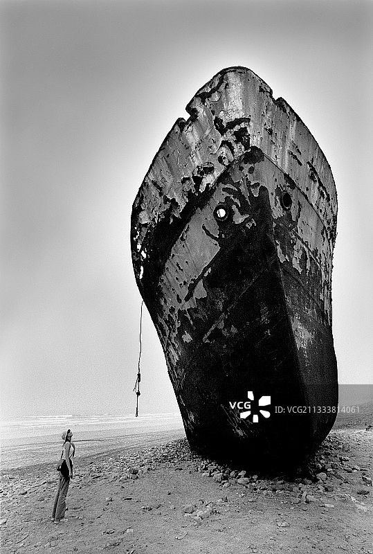 游客观看搁浅在摩洛哥海滩上的货轮图片素材