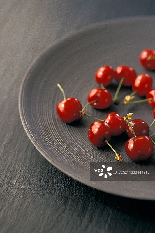 灰色盘子里的法国樱桃图片素材