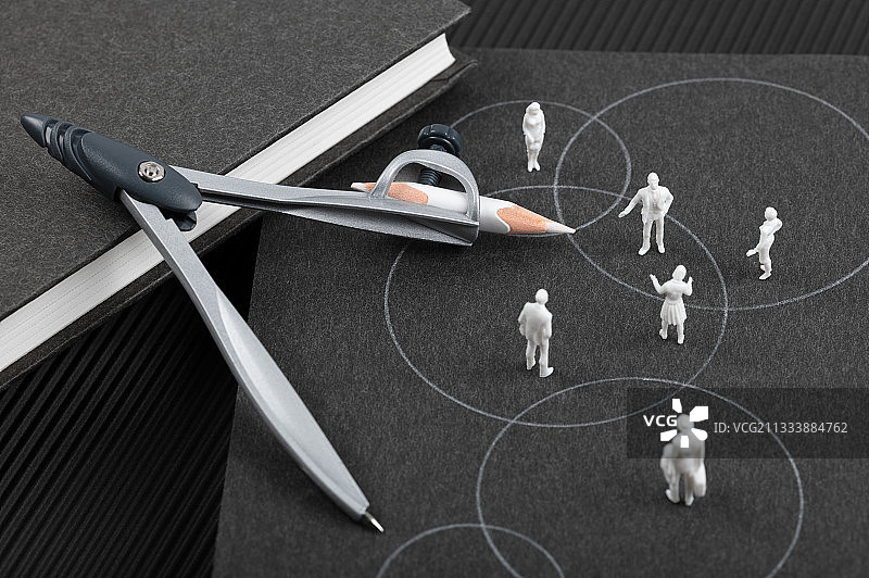 圆规黑色书本上的白色圆圈不同立场讨论交流图片素材