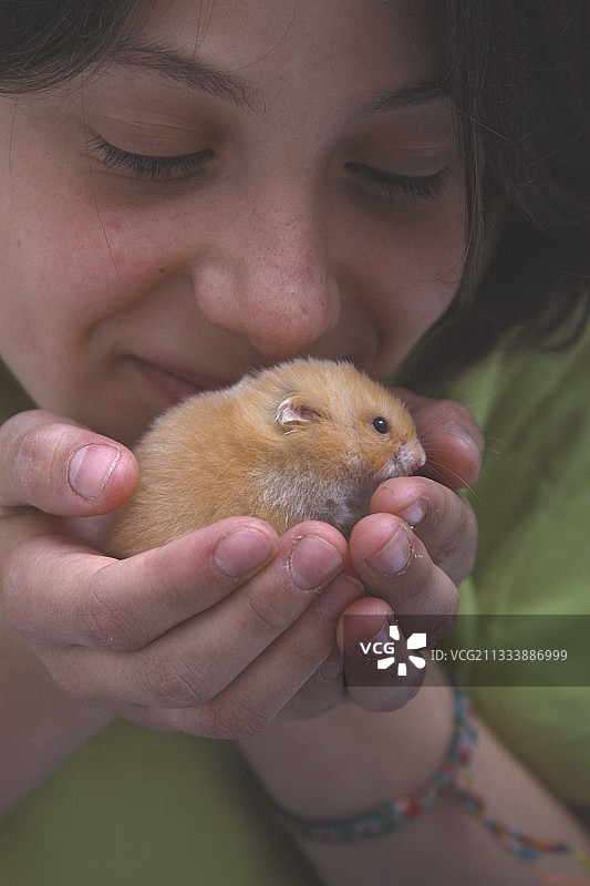 年轻女人手捧宠物仓鼠图片素材
