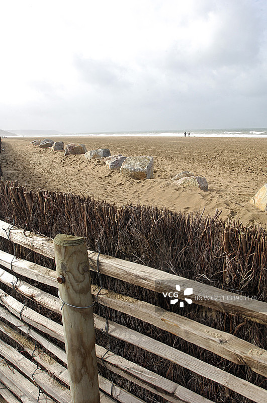 法国多维尔海滩上的木栅栏和岩石图片素材