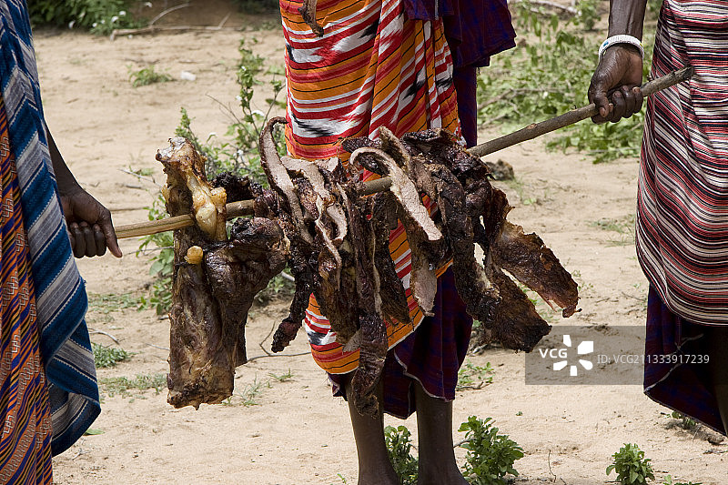 坦桑尼亚马赛人搬运烤牛肉图片素材