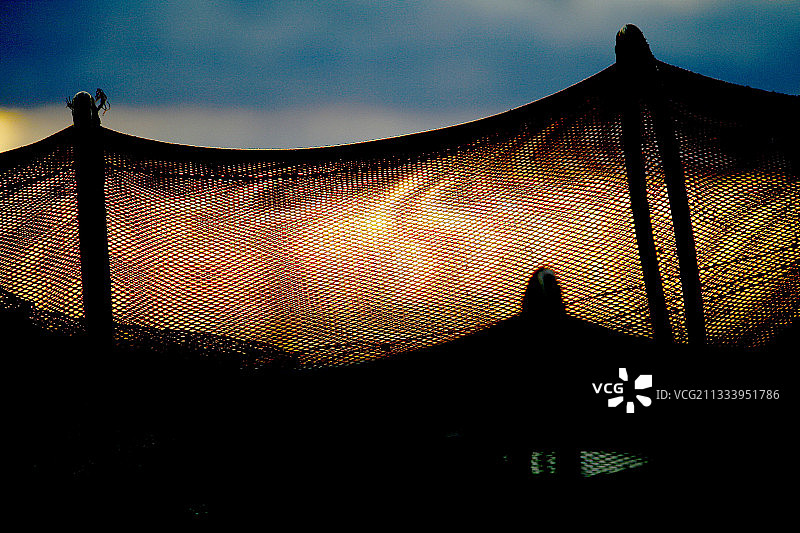 日落时分晾晒的捕鱼陷阱图片素材