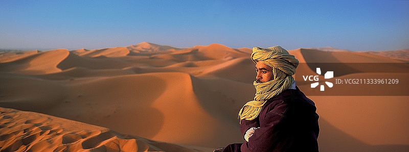 在摩洛哥梅尔祖卡撒哈拉沙漠沙丘上的男人图片素材