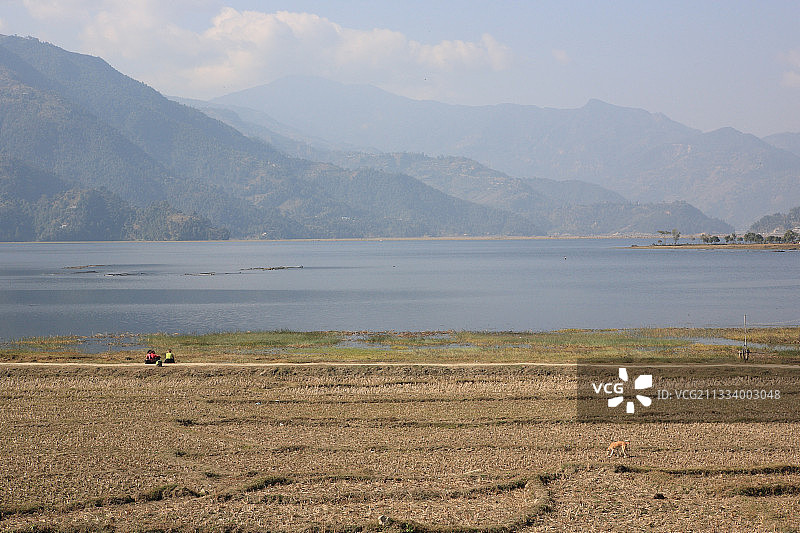 坐在尼泊尔费瓦湖安纳普尔纳峰前的妇女图片素材