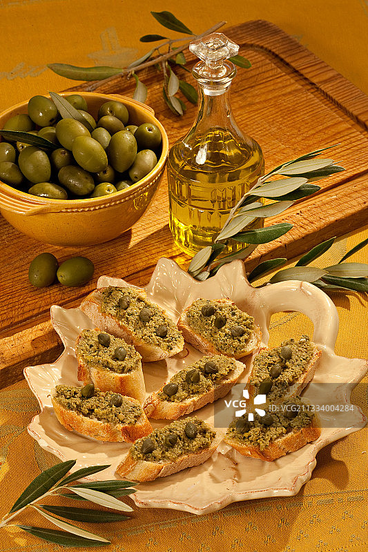 绿色橄榄酱和刺山柑配橄榄油烤面包片图片素材