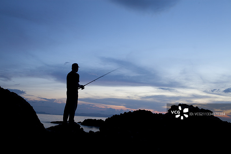 黄昏时分，苏门答腊岛Pulau Weh岩石上的渔夫图片素材